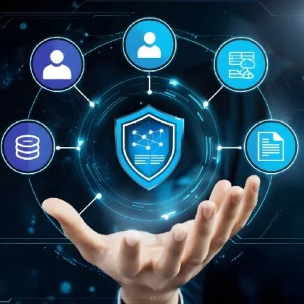 Hand supporting a glowing shield with a network diagram, surrounded by circular security icons (user, database, documents, chat) indicating cybersecurity protection.