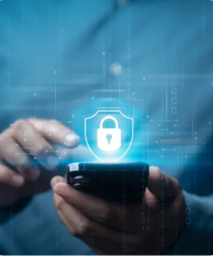 Person using a smartphone with a glowing shield-and-lock icon above it, symbolizing mobile cybersecurity.